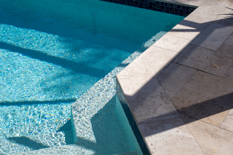 Pool corner showing steps, waterline tile, and stone coping